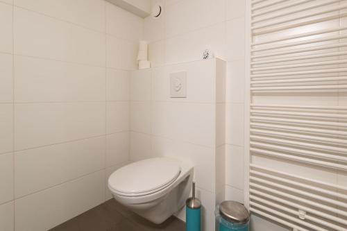 a white bathroom with a toilet and a shower at Quiet apartment for 4 at park in center in Amsterdam