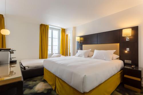 A bed or beds in a room at Hôtel 15 Montparnasse