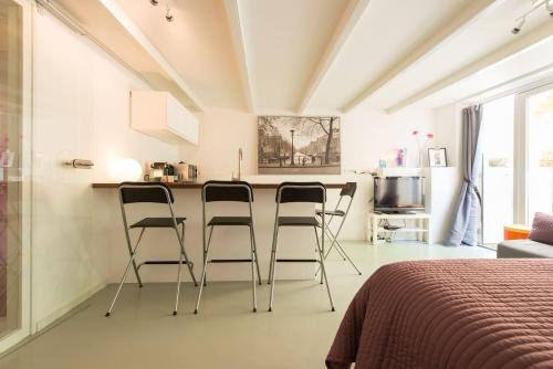 a kitchen with three bar stools in a room at Quiet apartment for 4 at park in center in Amsterdam