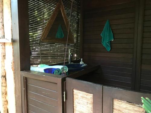 ein Bad mit einem Waschbecken, einem Spiegel und einem Handtuch in der Unterkunft Serenity Beaches Resort in Uoleva Island