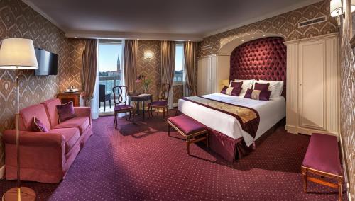 a hotel room with a bed and a chair at Londra Palace Venezia in Venice
