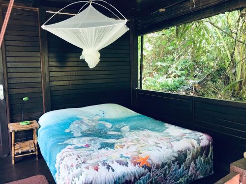 Bett in einem Zimmer mit Fenster in der Unterkunft Serenity Beaches Resort in Uoleva Island
