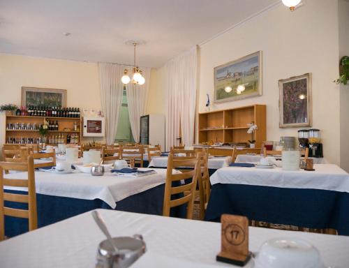 un ristorante con tavoli e sedie con tovaglie bianche di Hotel Casa Mia a Lido di Jesolo