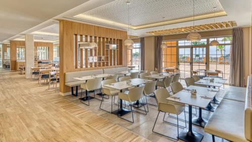 a restaurant with tables and chairs and windows at Playamojácar in Mojácar