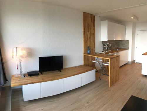cocina con TV de pantalla plana en una encimera en PERCHOIR 1 : Studio haut de gamme et lumineux en Turckheim