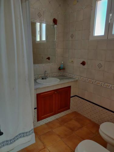 y baño con lavabo, espejo y aseo. en Casa Josefina, en Yátova