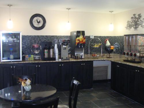 a kitchen with a table and a clock on the wall at Econo Lodge Inn & Suites Jackson Northwest in Jackson