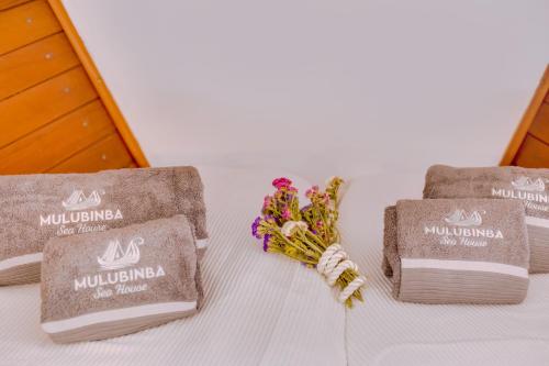 a table with two towels and flowers on it at Mulubinba SeaHouse in Olhão