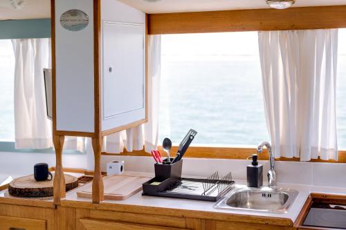 a kitchen counter with a sink and a window at Mulubinba SeaHouse in Olhão