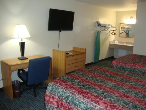 a hotel room with two beds and a desk and a television at Econo Lodge Inn & Suites Jackson Northwest in Jackson