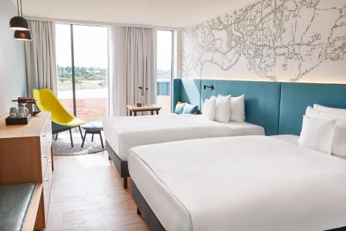 una habitación de hotel con 2 camas y un mapa en la pared en Steigenberger Alsik – Hotel & Spa en Sønderborg