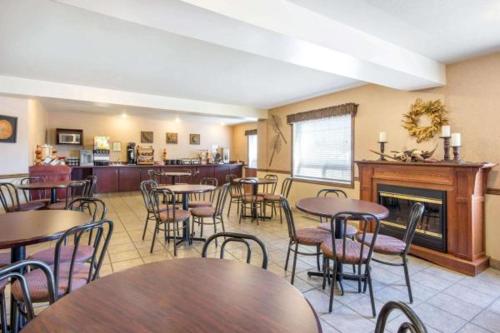 a restaurant with tables and chairs and a fireplace at Gold Circle Inn in Lloydminster