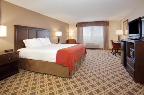 a hotel room with a bed and a flat screen tv at Holiday Inn Express Show Low by IHG in Show Low