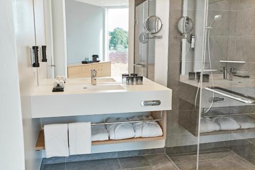uma casa de banho com um lavatório e um chuveiro em Steigenberger Alsik – Hotel & Spa em Sonderborg