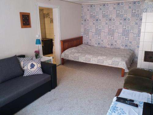 - un salon avec un canapé et un lit dans l'établissement Viljandi Paadimehe Apartment, à Viljandi