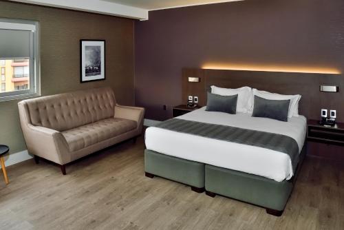 a hotel room with a bed and a couch at Radisson Hotel Curico in Curicó