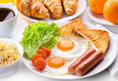 a plate of breakfast food with eggs bread and vegetables at Comfort House in Kyiv