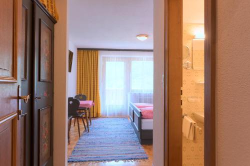 a hallway with a room with a bed and a window at Pension Angelika in Pettneu am Arlberg