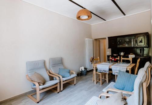 een woonkamer met 2 stoelen en een tafel bij La Quiete del Roero - Casa Vacanze nel verde in Monticello d'Alba