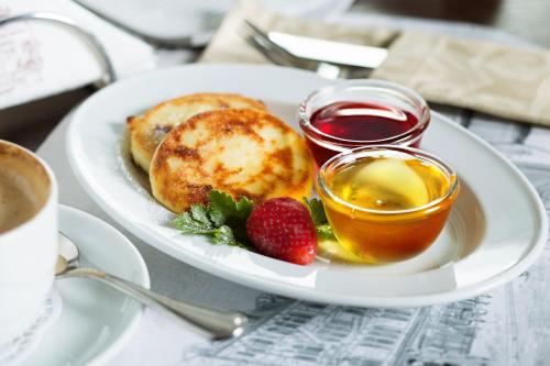 a plate of food with pancakes and strawberries on a table at Comfort House in Kyiv