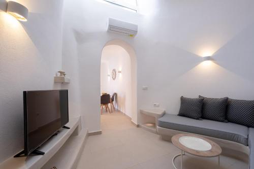 a living room with a couch and a tv at Santoterra Antigua Suites in Karterados