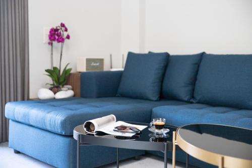 a blue couch in a living room with a table at Olygreen Athens Residences in Athens