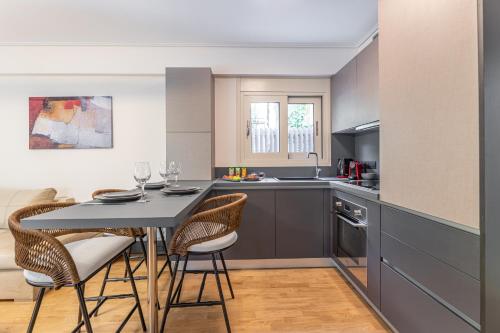 a kitchen with a table and chairs in a kitchen at Olygreen Athens Residences in Athens