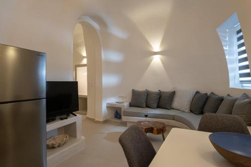 a living room with a couch and a tv at Santoterra Antigua Suites in Karterados