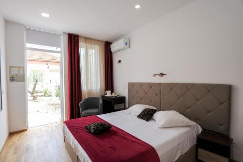 - une chambre avec un grand lit et une couverture rouge dans l'établissement Le Vauban, à Villefranche-sur-Mer