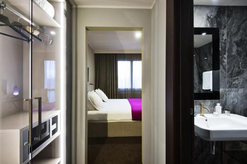 a bathroom with a bed and a sink and a mirror at Terme di Relilax Boutique Hotel & Spa in Montegrotto Terme