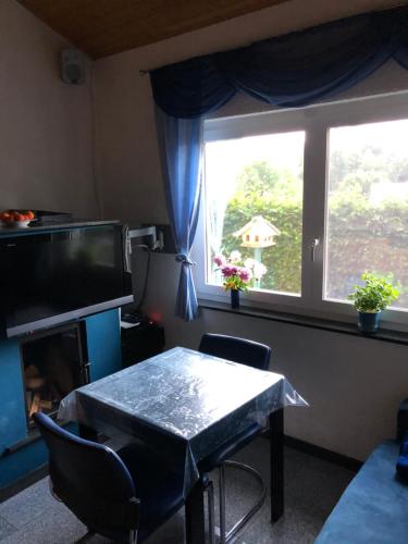 ein Wohnzimmer mit einem Tisch und einem Fenster in der Unterkunft Ferienhaus zur Blautanne in Klipphausen
