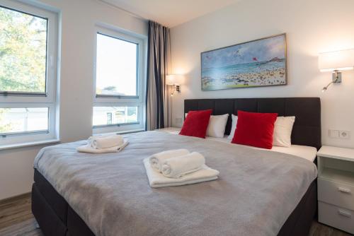 a bedroom with a large bed with towels on it at Appartement "Karat" mit Penthouseflair - Oase am Haff in Garz