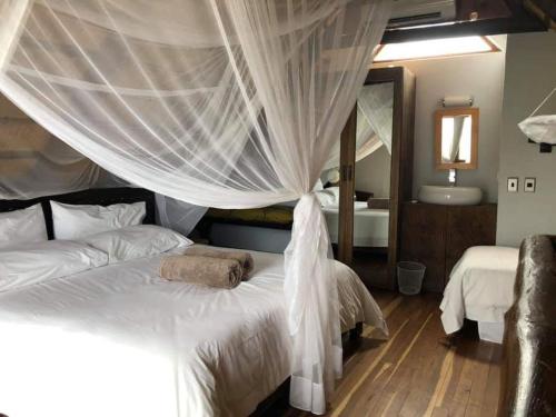 a hotel room with a bed and a canopy at Von Bach Dam Resort in Okahandja