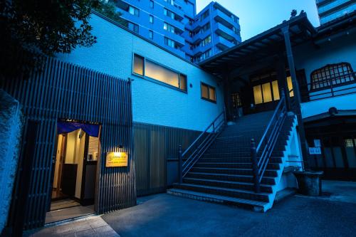 un edificio azul con escaleras delante de un edificio en 宿坊 正伝寺 Temple hotel Shoden-ji, en Tokio