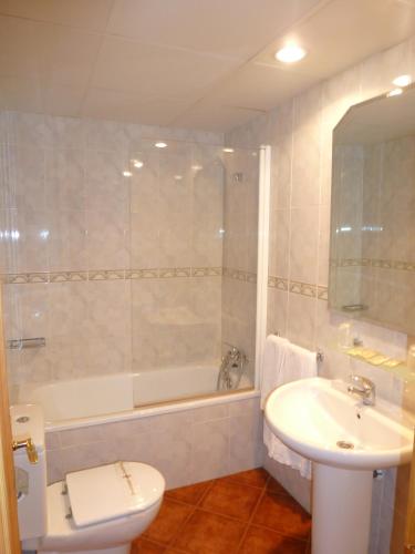 a bathroom with a sink and a toilet and a tub at Hostal Pañart in Bielsa