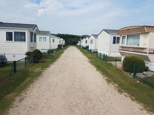un chemin de terre bordé de maisons en une rangée dans l'établissement Seacottage Blankenberge - Wenduine, au Coq