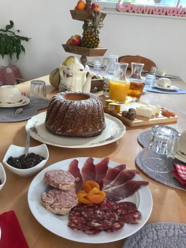 una mesa cubierta con platos de comida y un pastel en Chambres d'hôtes Maison Efftermatten, en Andlau