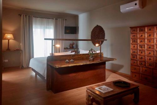 a bedroom with a bed and a table in it at Quinta da Abelheira in Ponta Delgada