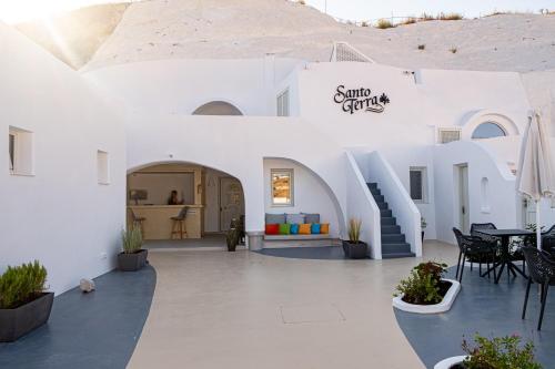 a white building with a table and chairs at Santoterra Antigua Suites in Karterados