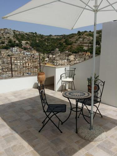 a patio with a table and chairs and an umbrella at Casa Mireio in Modica