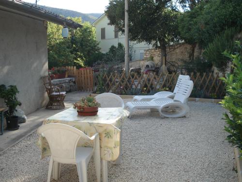 a patio with white chairs and a table with a plant at Abruzzo Segreto in Navelli