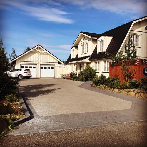 a house with a car parked in a driveway at The White House in Reykholt