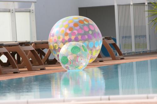 un huevo grande sentado en la parte superior de una piscina en Hotel Luciana, en Bibione