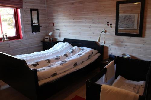 a bedroom with a bed with a blanket on it at Solberg 10 persons cabin in Myro