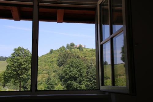 an open window with a view of a hill at Wein Lodge Durbach - Schlossblick in Durbach