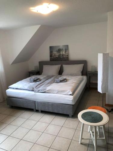 a bedroom with a bed and a table and a chair at Wein Lodge Durbach - Schlossblick in Durbach