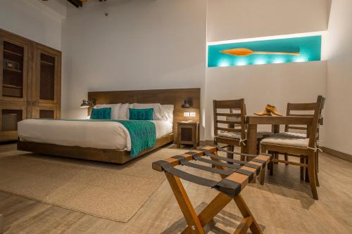 a bedroom with a bed and a table and a chair at Sophia Hotel in Cartagena de Indias