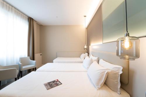 a hotel room with two beds and a window at Hotel Milano Castello in Milan