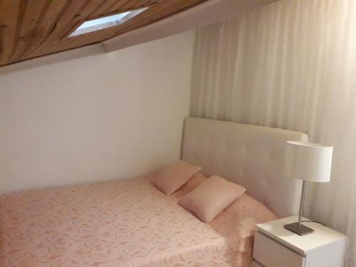 um pequeno quarto com uma cama e um candeeiro em Sesimbra Beach Fonte House em Sesimbra