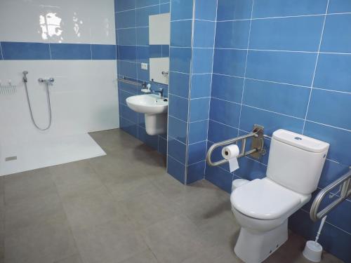 a blue tiled bathroom with a toilet and a sink at Hostal Delia in Alora